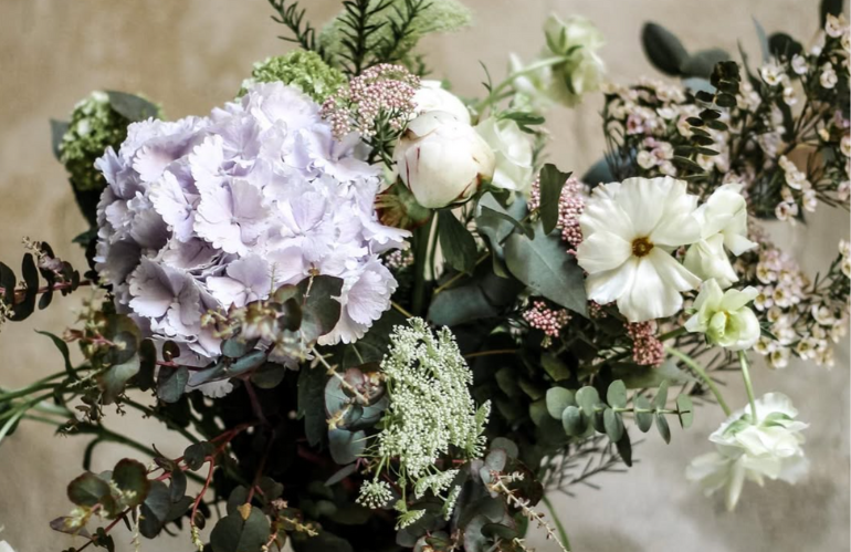 Libri e riferimenti d’arte accanto a composizioni floreali